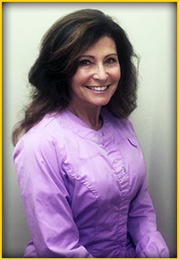 A woman wearing a purple jacket stands against a white background.